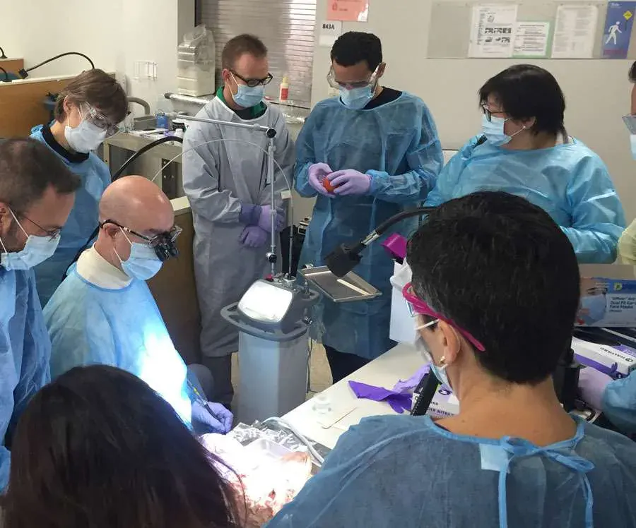 Clinicians gathered around LightScalpel equipment during a training workshop